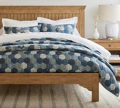 a bed with blue and white bedspread in a bedroom next to two nightstands