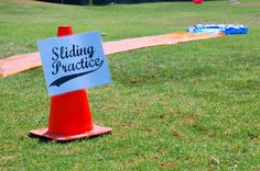 a sign sitting on top of a red cone in the middle of a grass field