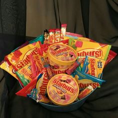 a bowl filled with candy sitting on top of a black cloth covered table next to a bag of gummy bears