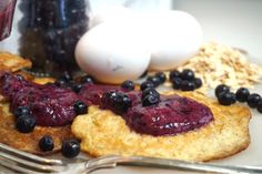 blueberries and other food items on a plate next to an egg, milk, and utensils