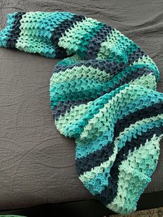 a crocheted blanket laying on top of a bed