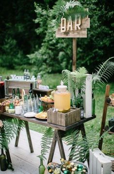 an outdoor bar set up with drinks, snacks and other things to eat on the table