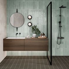 a bathroom with a sink, mirror and shower head in the middle of the room