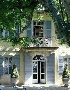 an old house with blue shutters and balconies on the second floor is shown