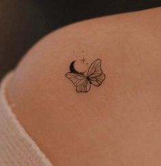 a small butterfly tattoo on the back of a woman's shoulder