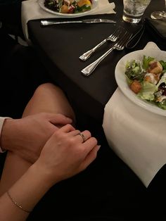 a woman sitting at a table with two plates of food and silverware on it