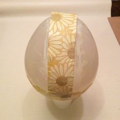 a glass ball with flowers on it sitting on a table next to a piece of paper