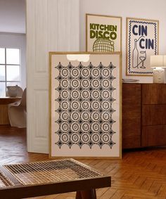 a kitchen with wooden flooring and art on the wall, including an open door