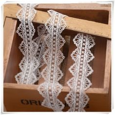 white lace is hanging in a wooden box