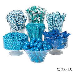 a blue vase filled with candy canes and candies on top of each other