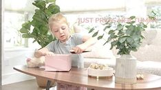 a little boy that is sitting at a table with a box in front of him