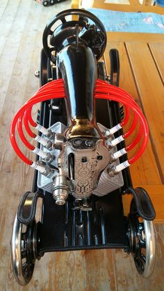 an image of a small motorcycle engine on display in a store or showroom with wood flooring