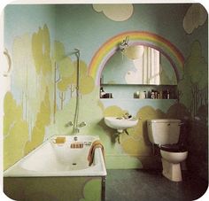 a bathroom with a rainbow painted on the wall next to a sink, toilet and mirror