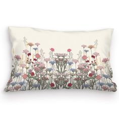 a white pillow with colorful flowers on the front and back side, along with a beige background