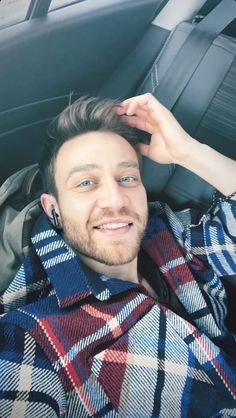 a man sitting in the back seat of a car with his hand on his head