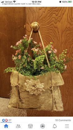 a flower pot hanging from the side of a wooden door with burlocks and flowers in it