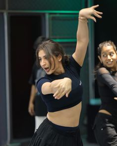 two young women are dancing on the dance floor