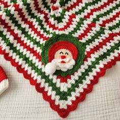 a crocheted christmas afghan with santa clause on it