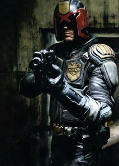 a man in a leather suit and red helmet holding his hand up to the camera