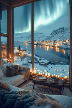 a living room filled with furniture next to a large window covered in snow and lit candles