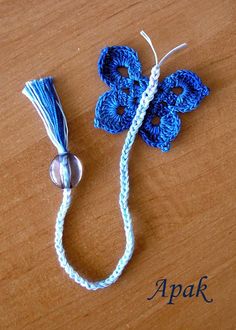 a crocheted blue flower on a white string with an ack button in the middle