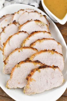 sliced pork on a white plate with mustard sauce