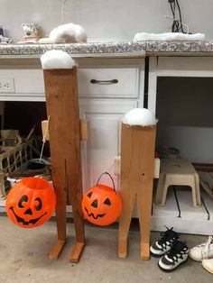 two pumpkins sitting next to each other in front of a kitchen counter with shoes on the floor