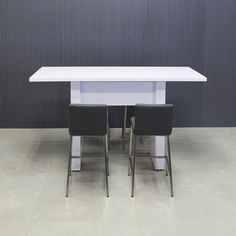 two black chairs sitting at a white table