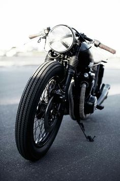 a black motorcycle parked on the street with its front tire still attached to it's seat