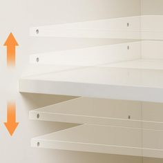 an orange arrow pointing to the left in front of white shelving with two shelves on each side