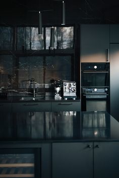 a kitchen with an oven, microwave and counter top in black marbled finish to it