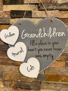 two hearts hanging on a brick wall with the words grandma and grandchilden written on them