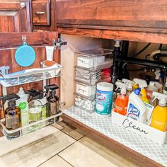 an under sink cabinet filled with cleaning products