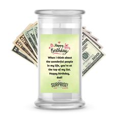 a jar filled with money sitting on top of a pile of hundred dollar bills in front of a white background