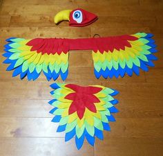 two colorful kites sitting on top of a wooden floor next to a toy snake