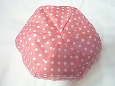 a pink and white polka dot covered pillow