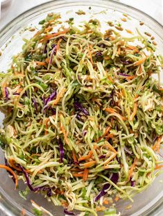 a glass bowl filled with shredded veggies on top of a white table cloth