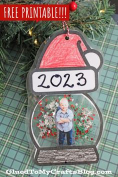 a christmas ornament hanging from a tree with the words free printable on it