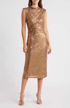 a woman wearing a gold sequin dress