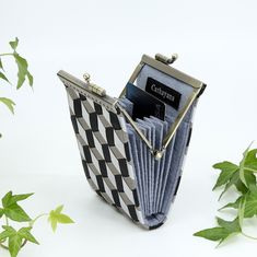 an open wallet sitting on top of a white table next to green plants and ivy