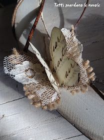 a white butterfly sitting on top of a piece of cloth next to a wooden floor