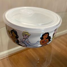 there is a plastic bowl with princesses on it sitting on the floor next to a wall