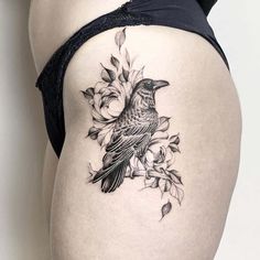 a woman's thigh with a bird and flowers tattoo on the side of her thighs