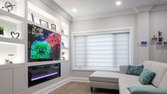 a living room filled with furniture and a flat screen tv mounted on a wall above a fire place