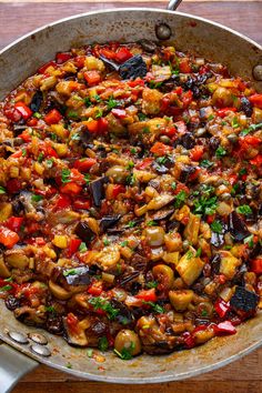 a pan filled with lots of food on top of a wooden table