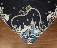 a black table cloth with blue and white designs on it, featuring santa's sleigh