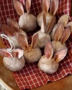 several rabbits are sitting in a bowl on a red and white checkered table cloth