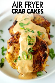 a white plate topped with crab cakes covered in gravy