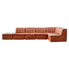 a brown leather sectional sofa with ottomans on it's back and footrests