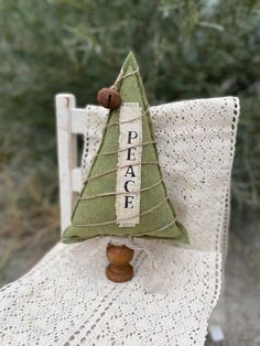 a small green christmas tree sitting on top of a white chair